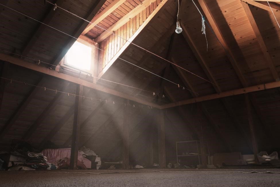 Attic with a window and sunbeam of light shining into the space.
