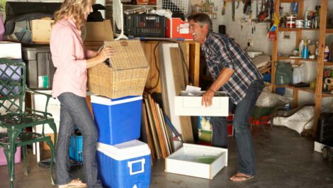 Smiling couple sorts through items in their garage