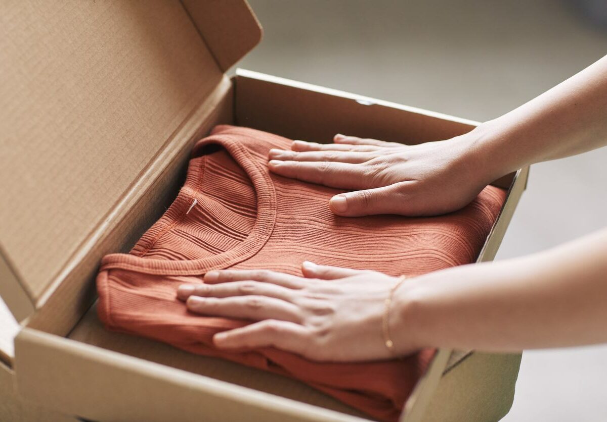 Woman packing a sweater into a box for storage