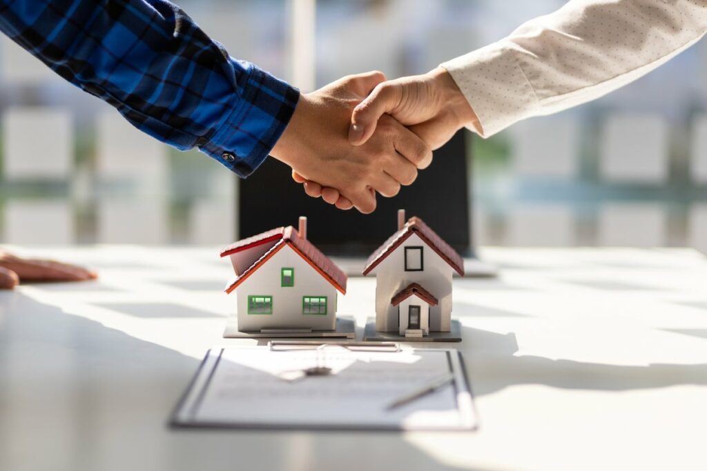 A handshake over the closing paperwork for a home