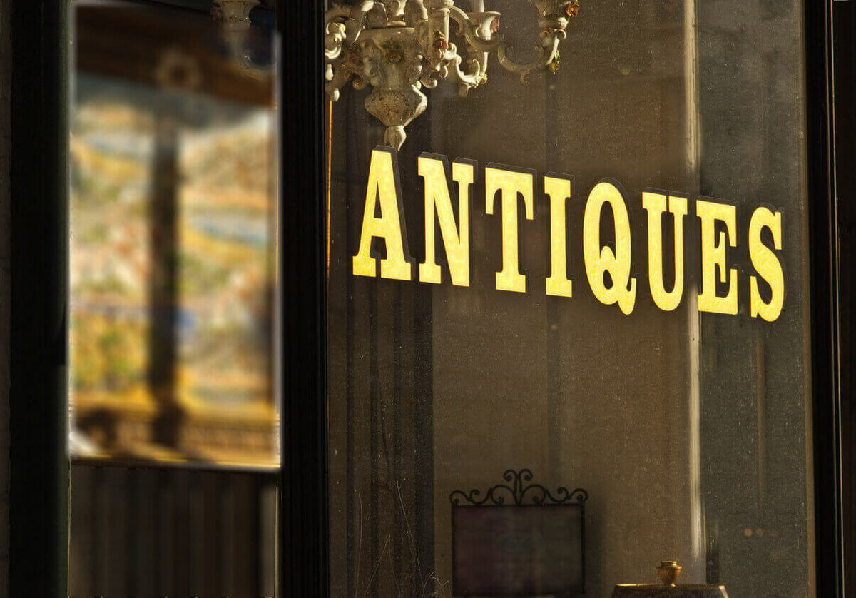 A sign to a store that says “antiques”